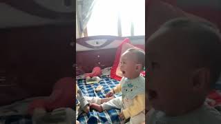 Baby twins sit and laugh in the house