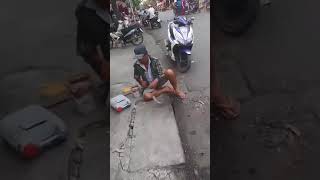 Mancing ikan di gorong-gorong pinggir jalan raya