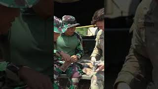 Sgt. Israel Gregory shares an American MRE with a TNI-AD soldier