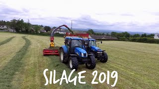 Trailed Harvester And A Fleet Of New Hollands Lifting Grass