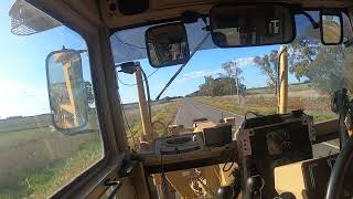 AUSTRALIA  GRADER DRIVES DOWN COUNTRY ROAD.268