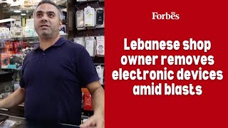 Lebanese shop owner removes electronic devices amid blasts