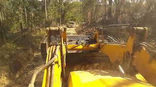 Retroescavadeira limpando beira da estrada(Backhoe cleaning the roadside)