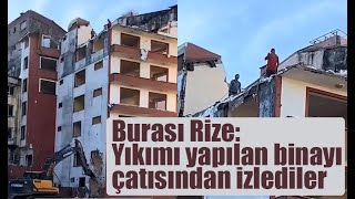 Rize’de yıkımı yapılan 6 katlı bir binanın çatı katında 2 kişi  iş makinesi çalışırken yıkımı izledi