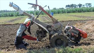 Farmer Tilling Dirt Using A Diesel Hand Tiller Tractor