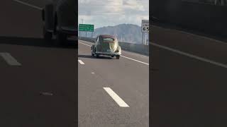 Vintage bug driving down the highway.