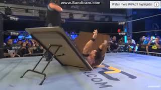 Abyss chokeslams Eli Drake through table