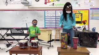 Ms.Turpin playing drums with her student