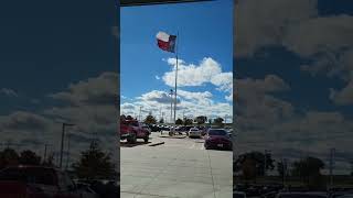 Texas Flag flutters in blue sky on a cold sunny day