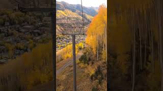 Riding through the golden fall foliage on the Telluride Gondola. Location: Telluride, Colorado, USA