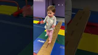 Sammi exploring the balance beam at little gym class, claps & applaud for herself