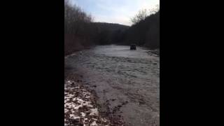 Outside view AJ driving jeep tru river