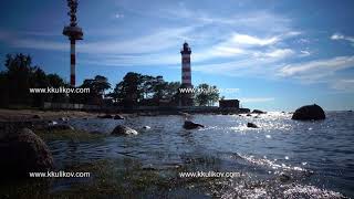 The building of the old beacon on the seashore against the background of the sky with brightly