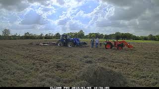 Unstucking a big tractor in mud using a small tractor