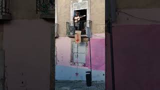 Musician playing music in their balcony to earn money in Lisbon - Portugal