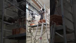 Demolition of walls with large hammers in the hall made of scaffolding