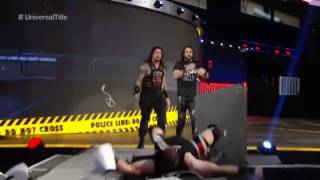 Roman Reigns and Seth Rollins powerbomb Kevin Owens through announce table