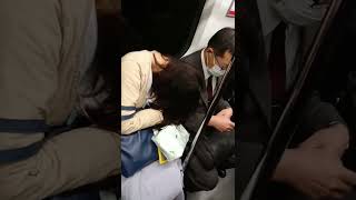 寝ている女性をスマホで殴る男