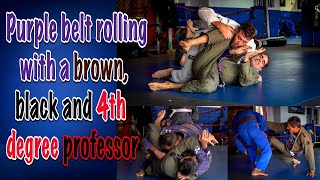 Purple belt rolling with brown, black belt and 4th degree professor