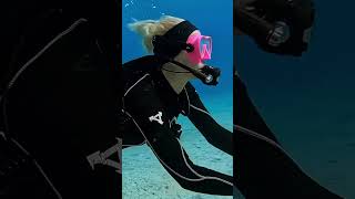 female scuba diver messing with her mask underwater