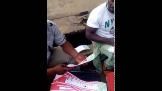 Vice Chairman of Mkpat Enin, with INEC staff thumbprinting behind INEC OFFICE