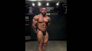 Muscle hunk Manuel Alvarez pose practice in black posing trunks