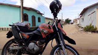 OLHA SÓ, moto com mercadorias  e capacete só, deixado na rua.