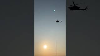 Helicopters fly over ocean