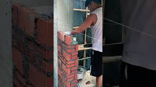 Construction workers in the process of building a wall