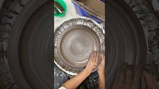 Throwing a dinner plate in dark clay