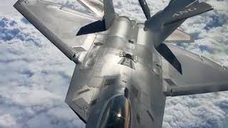 F-22 Raptor is refueled by a KC-135 Stratotanker in the blue sky