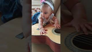 7 month old infant, playing guitar