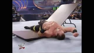 Kurt Angle pushes Chris Benoit through table