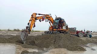 Heavy transpotting equipment loading by large excavator at river||large excavator working