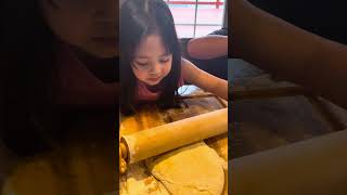 Little girl making cinnamon bread with her bruhs