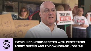 PM greeted by protests over hospital cuts during Dunedin flood visit | Stuff.co.nz