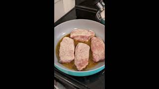 Cooking pork chops with corn and a salad.