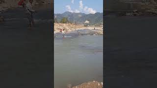 Local fisherman Catching Fish through fishnet in flowing river water.Beautiful scenic background.