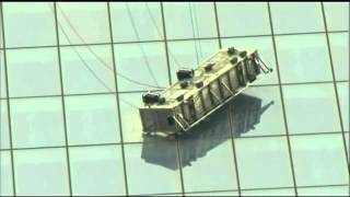 Scaffolding with two window washers dangles from One World Trade Center