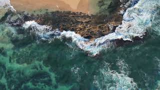 Waves on rocks and beach aerial shot - 10 minutes of relaxing DJI AIR 3 Footage