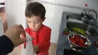 Niño pequeño cortando y limpiando fresas