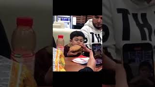 Boy eating face size burger jklmopiu