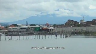 Argo Bromo Anggrek melintas tepi tambak dengan background gunung