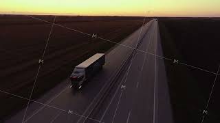 Aerial view. Automobile road at sunset. A truck is driving along the road. Cargo delivery. Two way