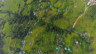 Aerial top down shot of colorful houses located on green slope in nepal FREE STOCK VIDEO