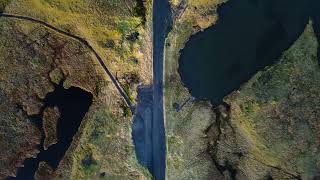 Abandoned mountain road with lakes in the faroe islands on a windy sunny day FREE STOCK VIDEO