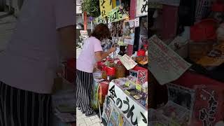 Ordering some pickled plums (ume Boshi) from a vendor in Shibamata.