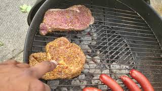 bbqing on the weber 22" charcoal grill steaks, chicken and beef sausages