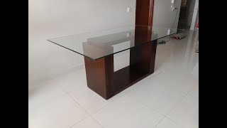 Wooden dining table base with glass top.