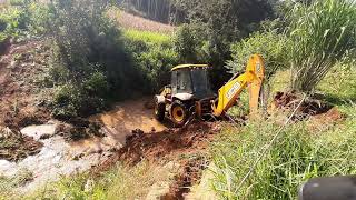 JCB retroescavadeira atravessando riacho(JCB backhoe loader crossing creek)